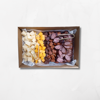 A platter containing an assortment of meats and cheeses, including pepperoni, sausages, and cubed cheddar cheese.